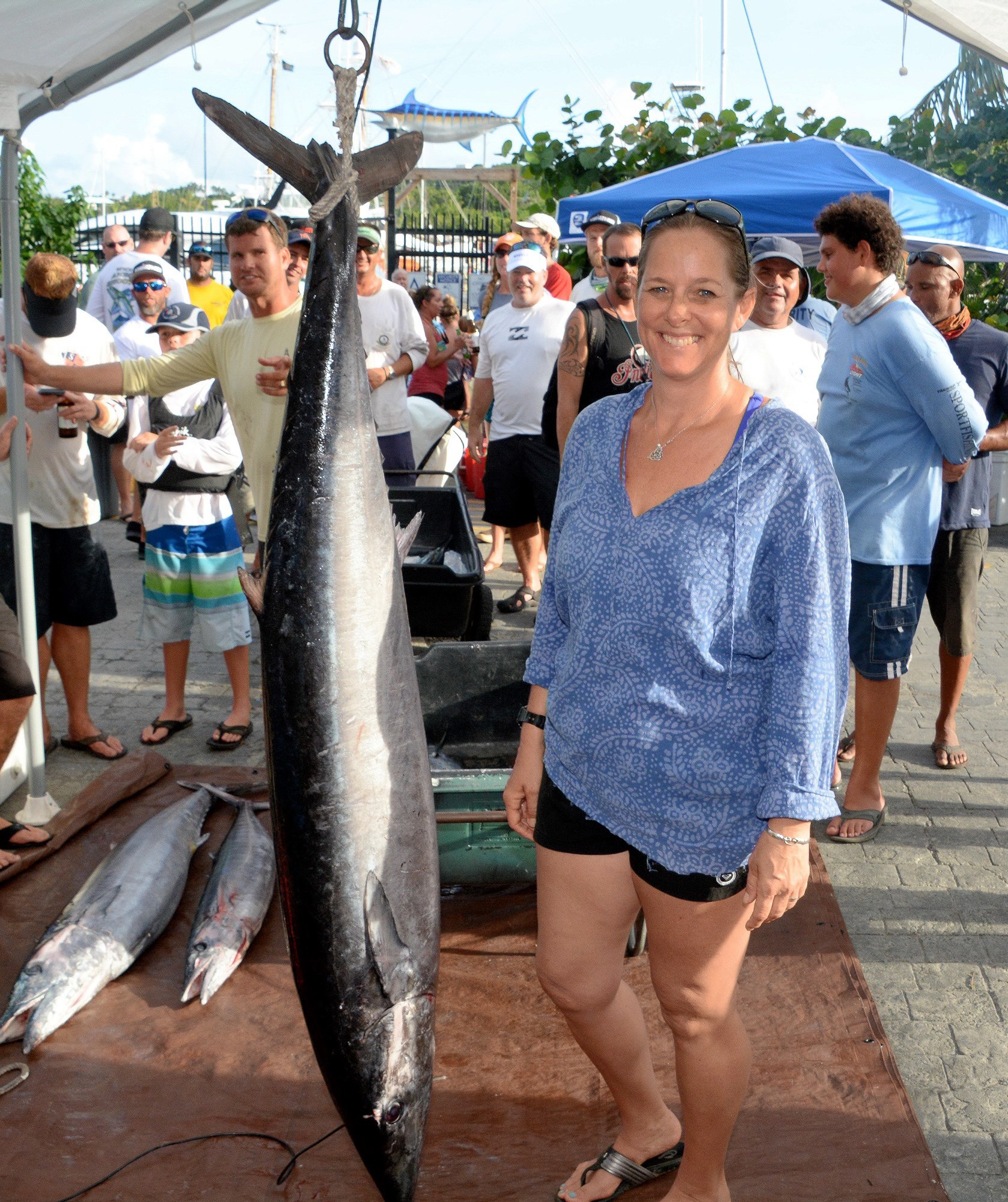 Adrianne Baird Butler stands next to her 76.3-pound wahoo at the weigh-in at IGY American Yacht Harbor Marina. (photo by Dean Barnes)