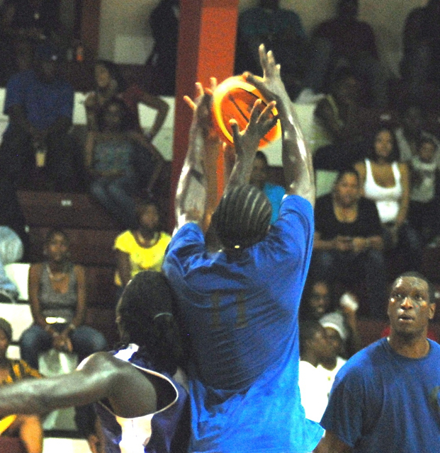 AQ St. Hillare, with his back to the camera, goes high for one of his 15 rebounds.