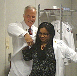 Keith Moore helps Jennifer Samuel of St. Croix into her white coat.