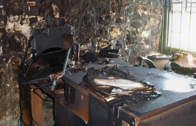 Charred remains of a computer and a report sit in the Women's Coalition's fire-ravaged office.