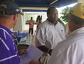 Tobias Augustin (center) hands his resume to Henry Cooper (left) and Marty Hayden of Sun Constructors.