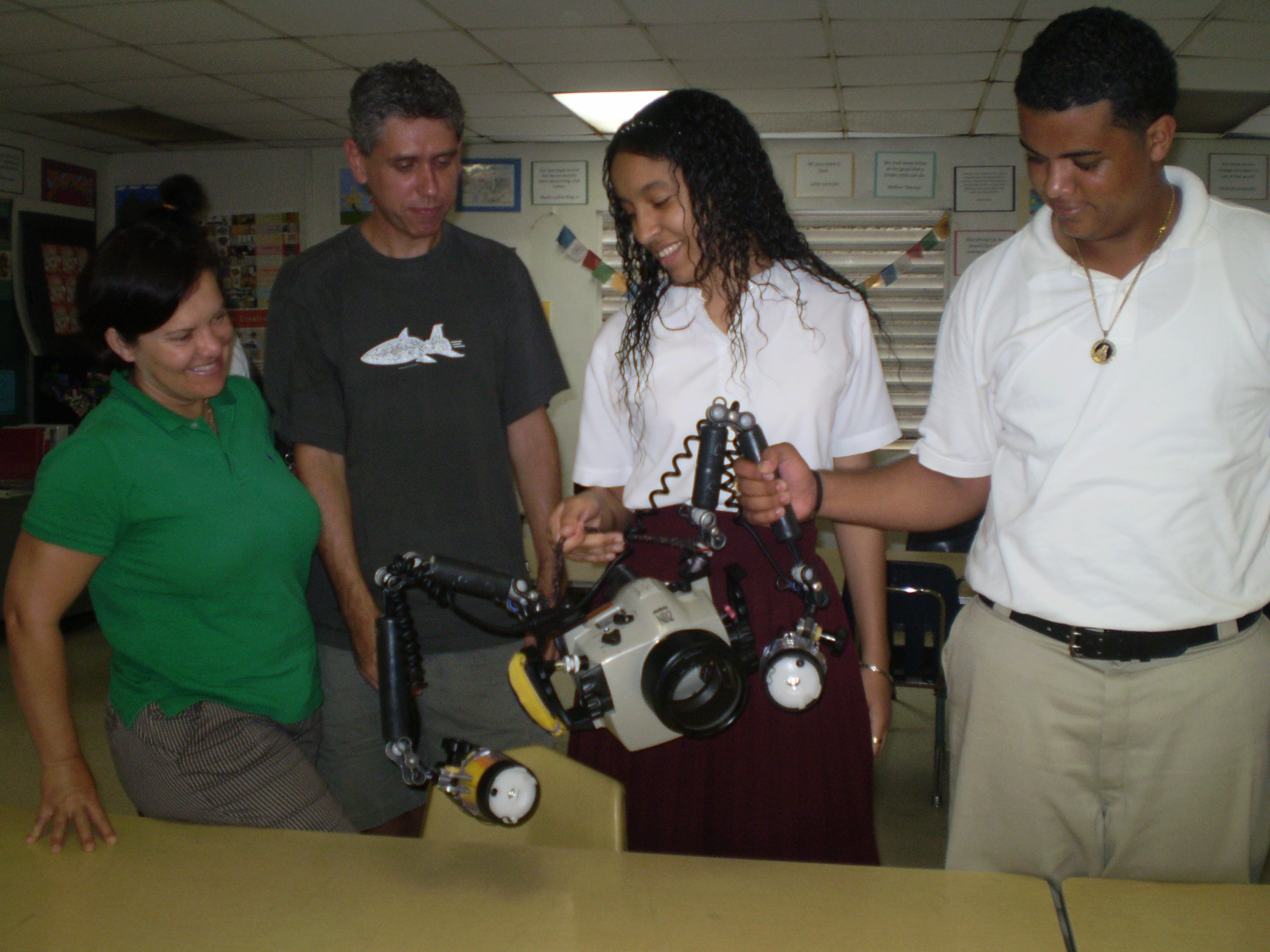 Julie Edwards (left) and Cor Bosman show students Yvette Encarnacion and Felix Garcia their underwater camera.