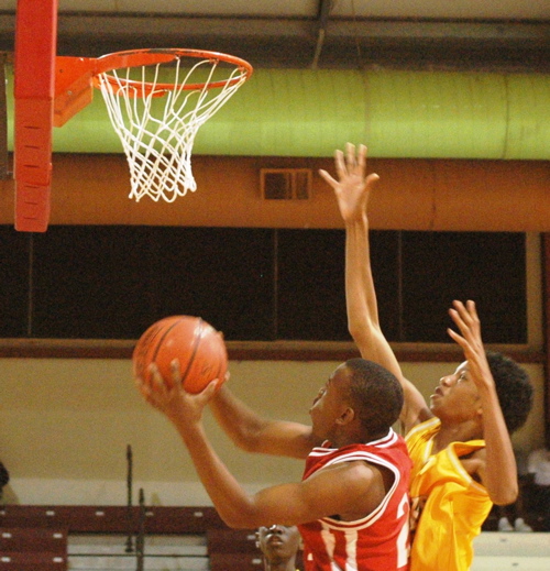 The Caribs&rsquo; S. James is fouled on a drive to the hoop.