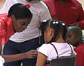 Josephine Hodge gives each child a red heart to wear.
