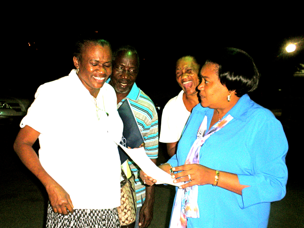 Edith Brown, Ashley Brown, and Cecilia Trotman get graduation status from "university" official Brenda Fredericks.