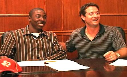 Jamaine Cotton signs with the Astros, accompanied by scout Greg Brown.