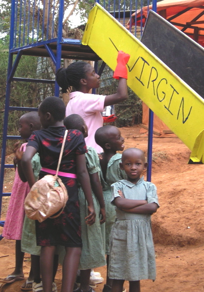 Sterelina Warner paints a slide while children cluster around her at Amizero Orphan Center, Kigali, Rwanda, in July 2008.