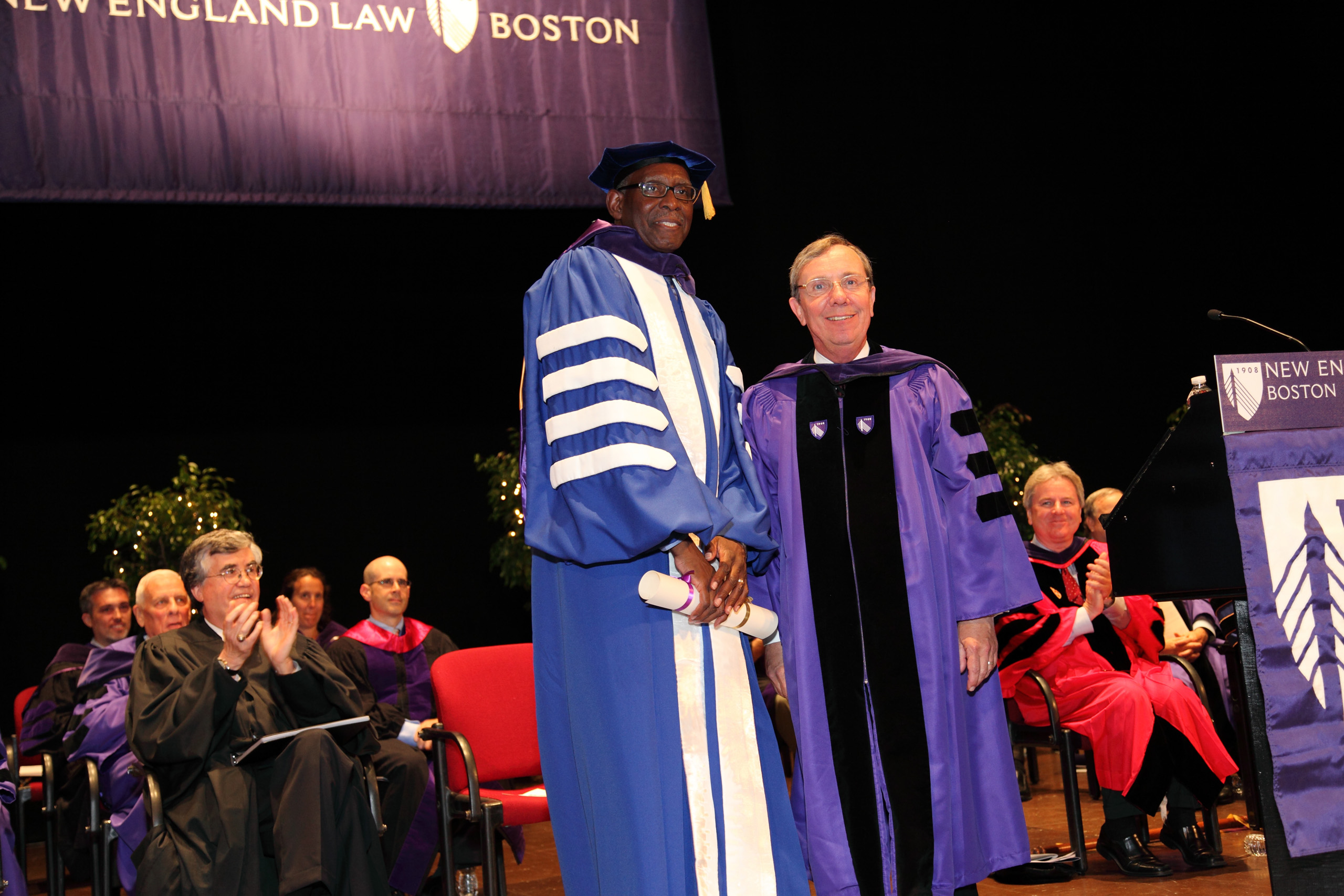 UVI President David Hall (left) accepts his honorary degree from school chairman Martin C. Foster