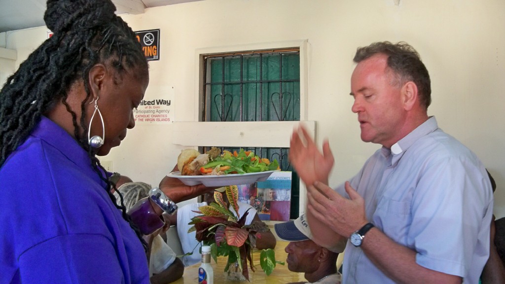 Kitchen manager Brenda Charles and Father Andrew Szorc bless the food.