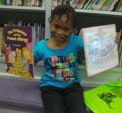 Allarie Monsanto shows off two of her favorite books on the St. Croix bookmobile.