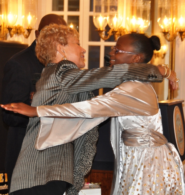 Women's Initiative founder Linda Appleton (left) embraces elementary student Krystahl Gordan, who read aloud a personalized thank-you note.