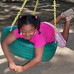 Amaya Evans relaxing on a tire swing.
