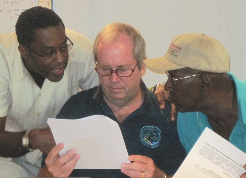 CZM attorney Winston Brathwaite (left) and CZM members Gerald Hills and Edmund Roberts review paperwork for the retention pond project. (Photo Lynda Lohr)