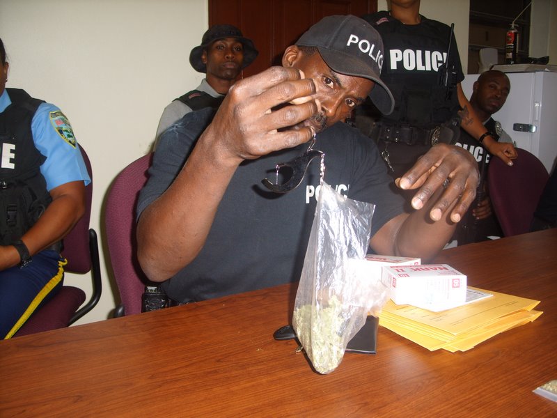 A VIPD officer examines drugs confiscated during the day's patrol. (Photo courtesy VIPD)