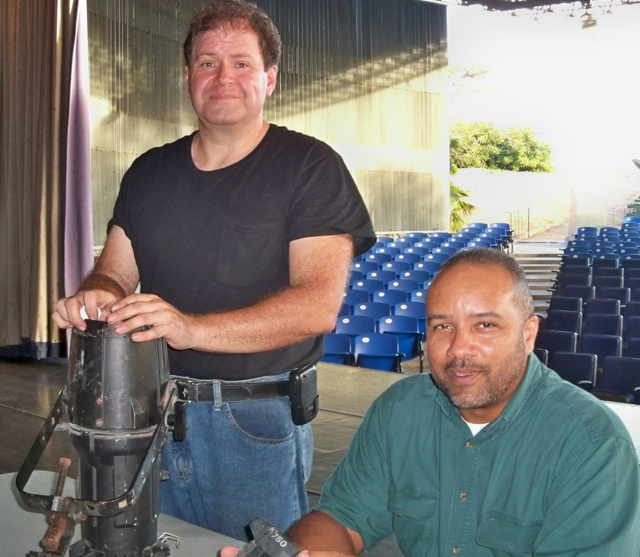 Doug Salisbury, left, and Rafael Llanos, Jr. do maintenance on lighting instruments at Island Center.