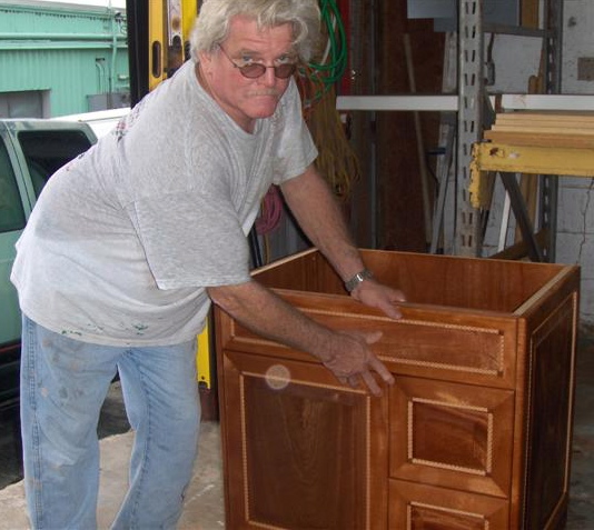 Andrew Watts with a cherry-wood cabinet.