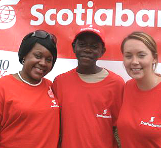 ScotiaBank's Christine Lee (left) and Amber Stein flank Boy Scout Esau David.