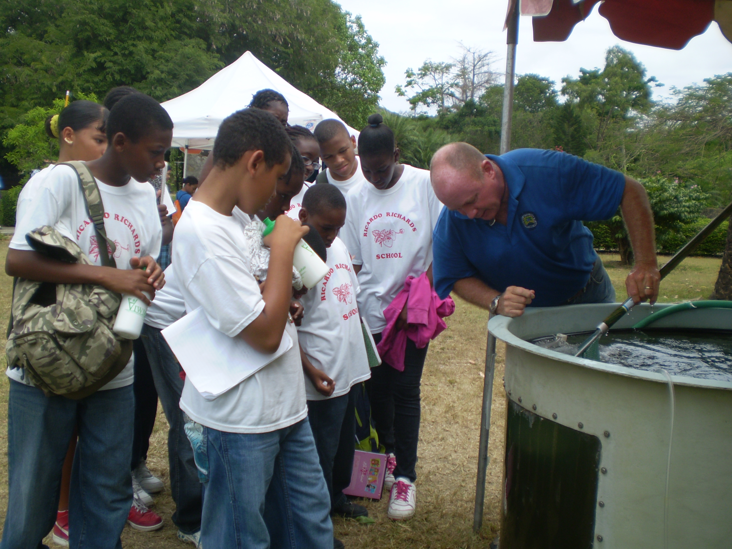 Don Bailey catching talapia for Ricardo Richards students to touch.