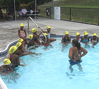 Dolphins swim coach Kie Ransom and a school of young swimmers.