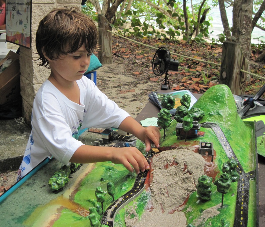 St. John resident Denny Bigrigg, 4, playing with peak-to-reef model sponsored by the V.I. Environmental Resource Station.