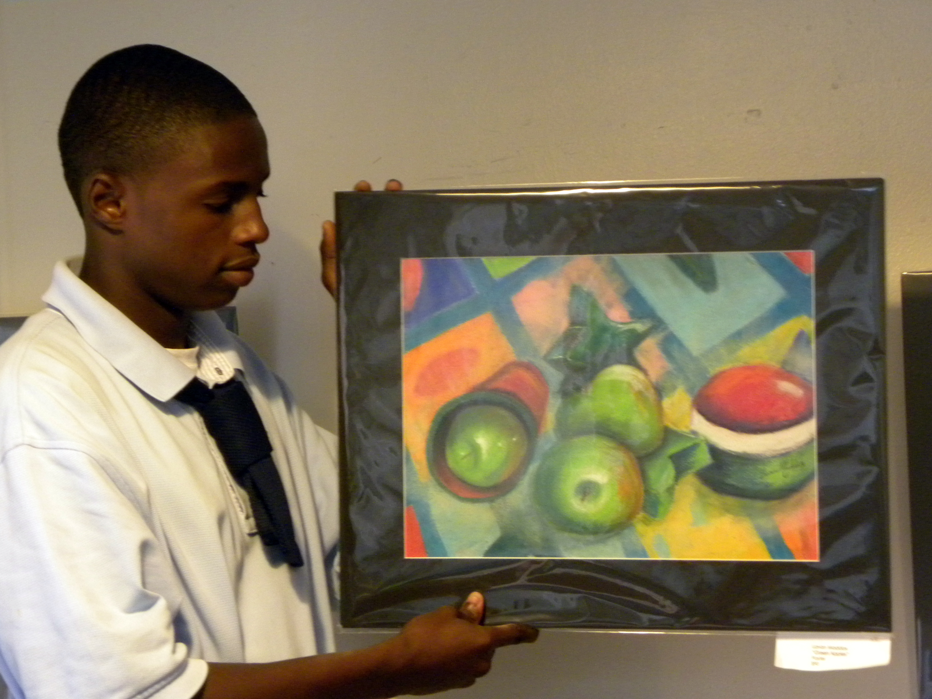 CAHS Senior Lavan Maddox, a student of the School of Visual Arts and Careers, holds his pastel, "Green Apples," currently on display at the Board of Education boardroom on St. Thomas.