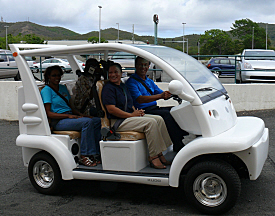 Carl Christensen of the U.S. Small Business Administration takes a solar SunBug vehicle for a spin Friday with Jewel Linzey, Karen Jane and Roman Richardson.