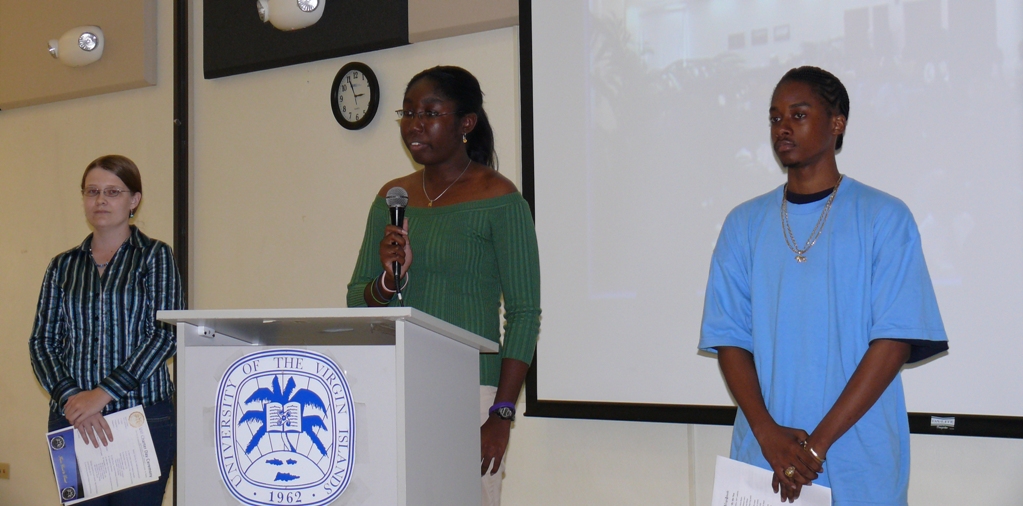 UVI student Kianna Harrigan speaks at Charter Day ceremonies on St. Croix while fellow students Cassandra Clifford and Trevoir Mapp look on.