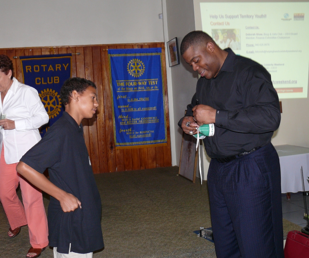 Super Bowl champion Roland Williams autographs the shoe of Kingshill School ninth-grader Emile Brin during Wednesday's Rotary Mid-Isle meeting.