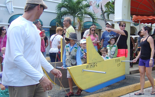 Kids crowd into a boat float that was led by Oreo in the Dog Parade.