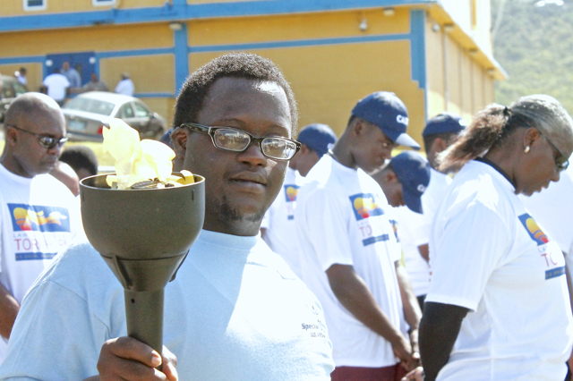 Leon Descortes proudly bears the Special Olympics torch Saturday at Charlotte Amalie High School.