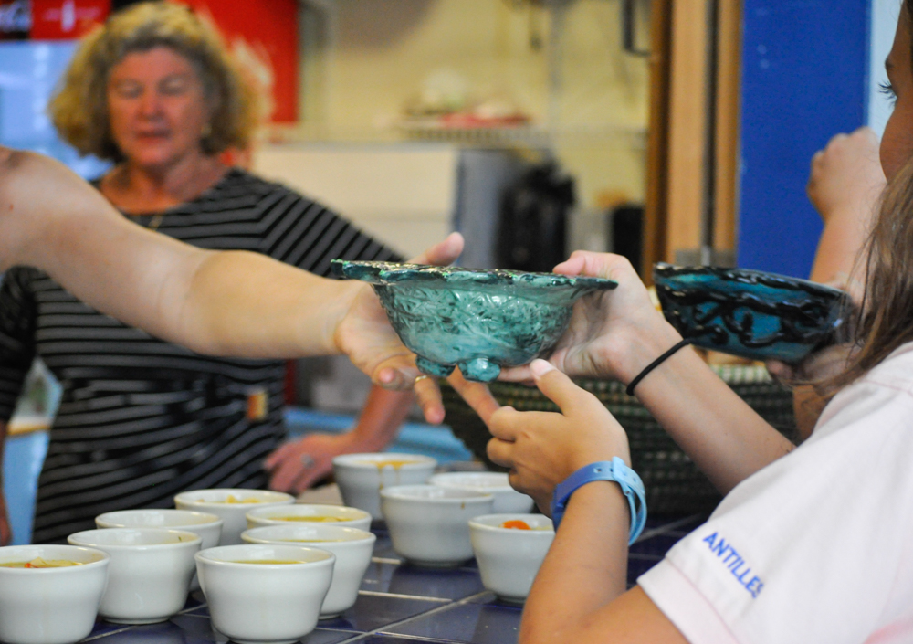 Antilles School middle schoolers are served soup in bowls they designed and made for the Empty Bowl Event.