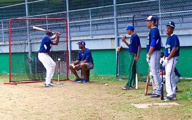 V.I. native Jabari Blash, sitting, helps Future Stars players with batting practice.