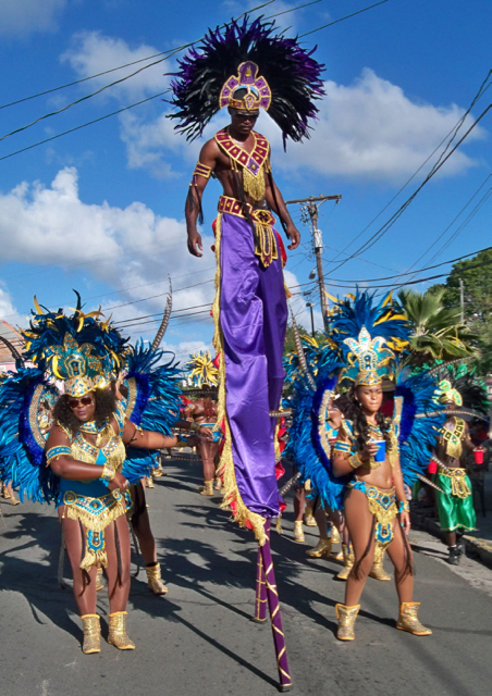 A stilt dancer towers above the parade.