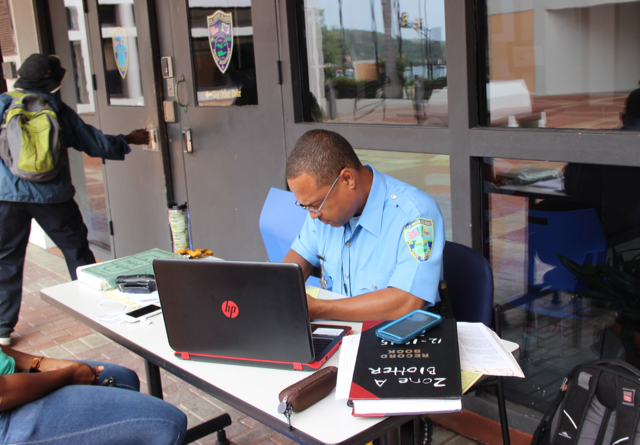 Office Derrick Bougouneau works outside the Alexander A. Farrelly Justice Center on St. Thomas Monday due to a foul odor in the building.