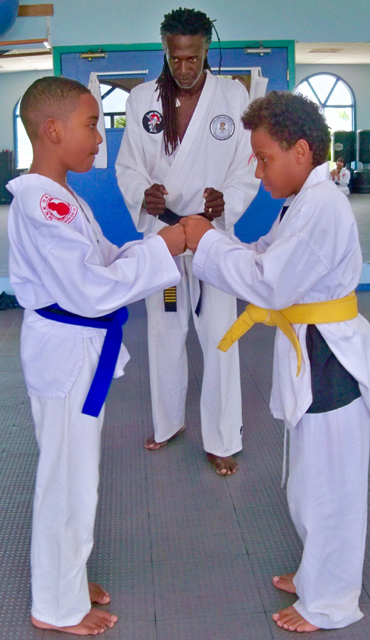 Jayden Navaro, left, and Cayden Ettienne prepare to bow to each other under Nelson's watchful eyes.