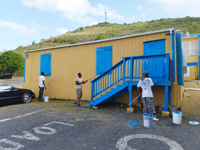 Student painters touch up a modular building. (Photo by the V.I. Department of Education)