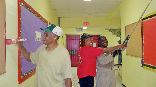 Legion members Floyd Petersen, Annie Day Henry and Gleston MacIntosh paint  Ricardo Richards.