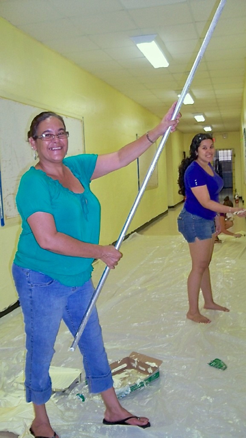 Yolanda Maldonado, grandmother of a Ricardo Richards student, and Jessica Nieves, a mother, help turn the school halls a cheerful yellow.