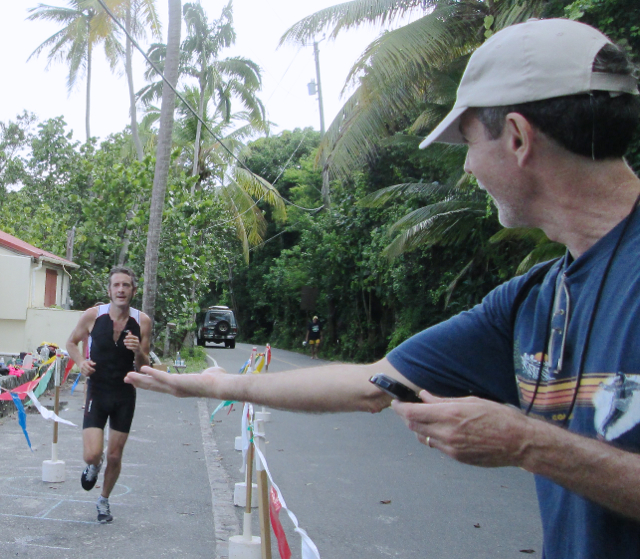 First-place men's triathlon finisher Brent Lynn approaches volunteer Bern Putnam.