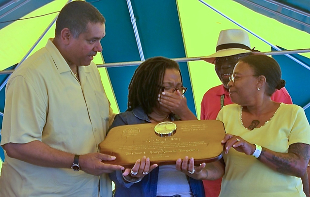 Gov. John deJongh Jr. presents a plaque honoring the late Oscar Henry to his daughters, Alice V. Henry, wiping away tears, and LeVelle T. Henry. 