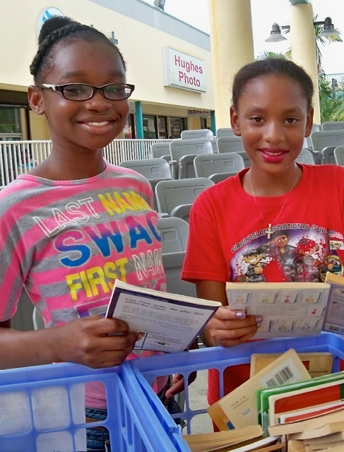 From left, Makayla Collins,11, and Sarah Joseph-Carino, 10, choose free books for the Governor's Reading Challenge.