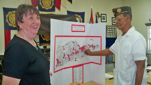 Cher Will watches Amos Seeley place a heart on the map showing the location of AEDs across St. Croix.