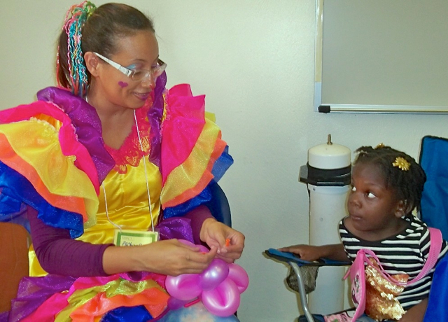 'Pachanga' ties a balloon for 4-year-old Alasia Woodley.