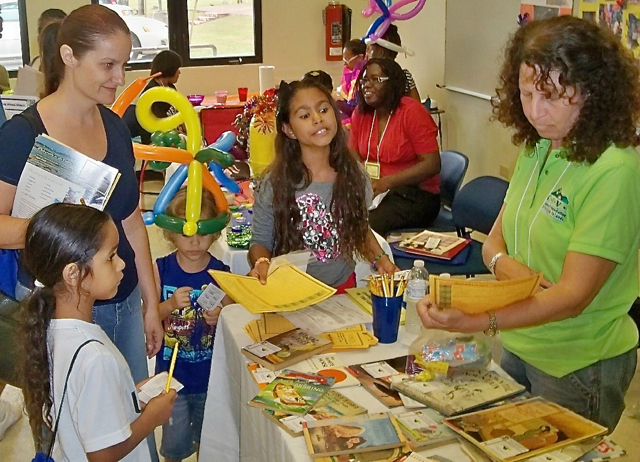 From left, Karma Codrington, Jennifer Atticot, Majah Atticot, I-Mani Codrington and Ellie Hirsh look over material at the 'Literacy for Life Big Bang.'