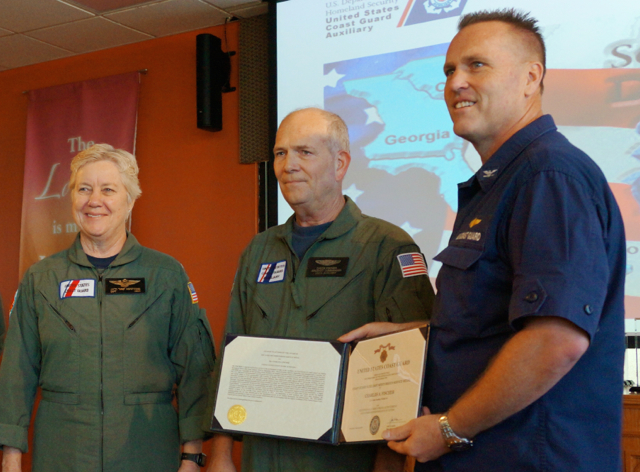 Charles 'Chuck' Fisher, right, receives the Auxiliary Meritorious Service Medal from Capt. Patricia A. McFetridge, Air Station Borinquen commanding officer, and Capt. Drew W. Pearson, U.S. Coast Guard Sector San Juan commander. (U.S. Coast Guard Auxiliary photo by Robert A. Fabich, Sr.)