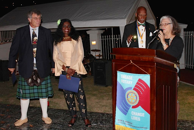 Shaun Pennington, president of Rotary Sunrise, honors her club's Harris awardees, Mike McKay, left, and Lynn Igwemadu.
