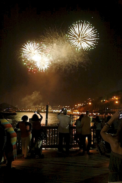 The crowd at Yacht Haven Grande whoops with delight as fireworks brighten the sky above Charlotte Amalie.