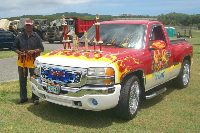 Charles Christian displays his flame-painted truck and the trophies it has won.