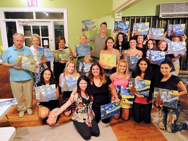 Members of Amy Gibbs' Uncorked Art program display their paintings from a recent class.