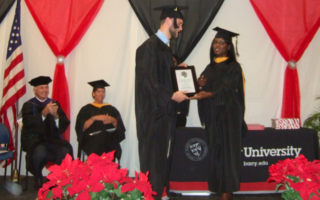 Shani Fleming, associate director of Clinical Education on St. Croix, presents the Presidential Award to Benjamin Shivar at Saturday's Barry University Physician's Assistant graduation in UVI's Great Hall. 